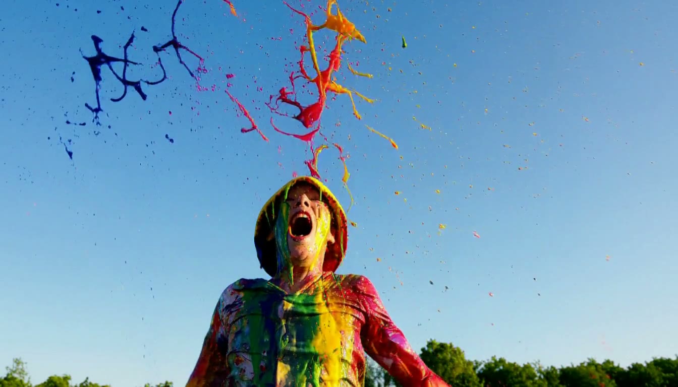 MiniMax H3 AI video example showing a person celebrating with colorful paint splashes in a vibrant outdoor setting