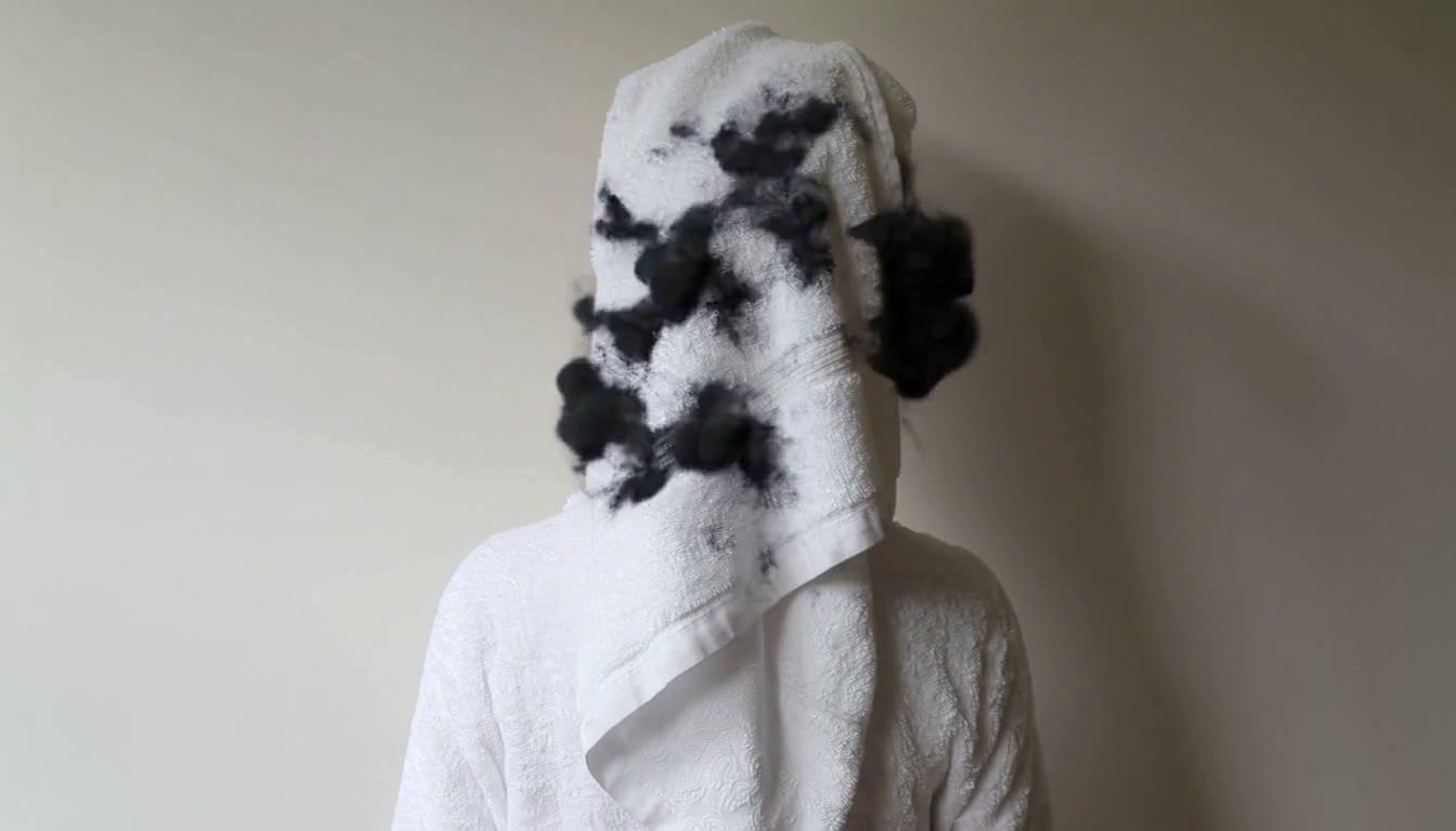 MiniMax H3 AI video example showing a person in a white bathrobe with a towel wrapped around their head